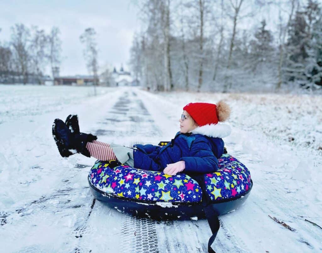 girl on an inflatable snow tube snow tubing near washington dc