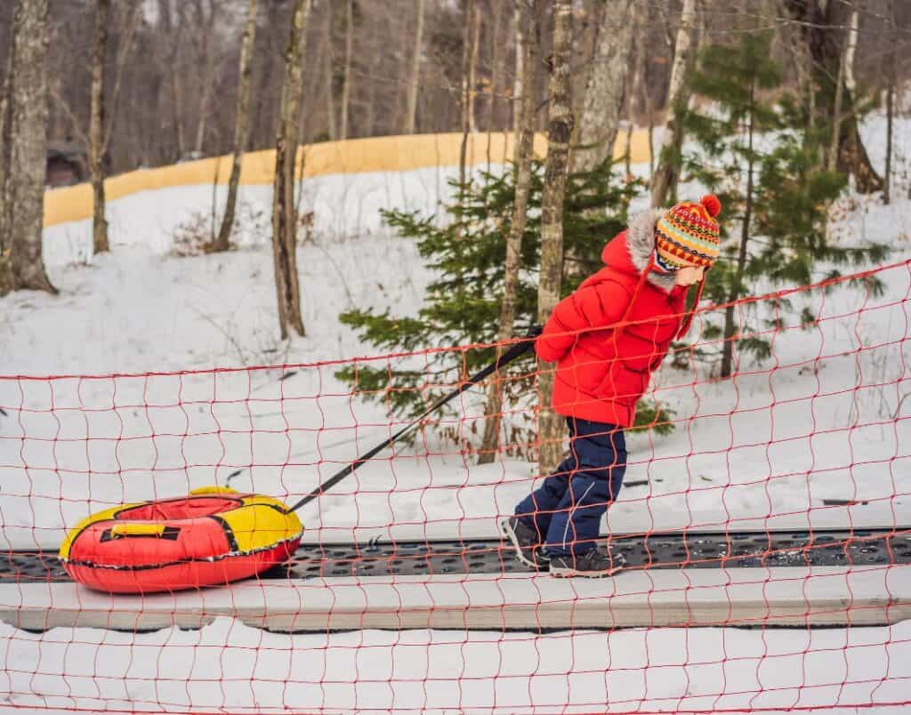 someone pulling up snow tube on magic carpet lift snow tubing near washington dc (6)