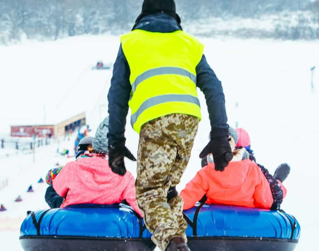 staff giving guests a push on snow tubes